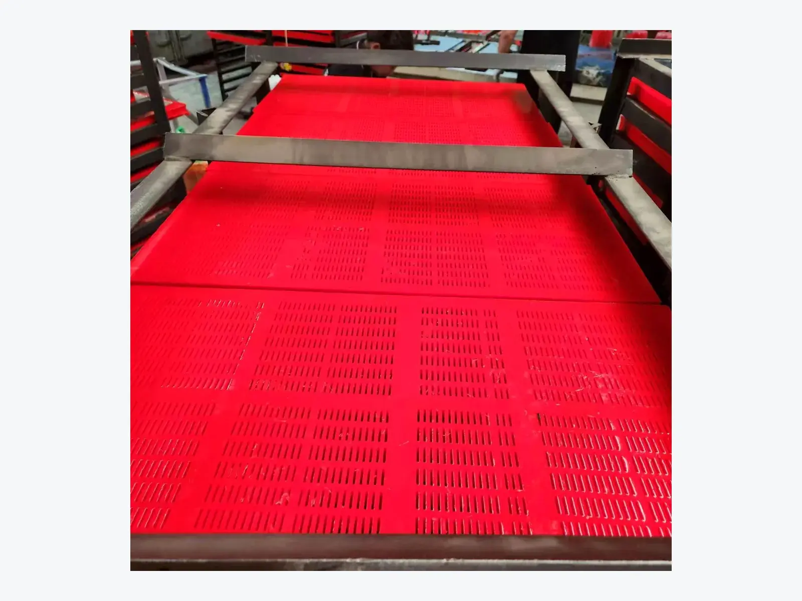 Polyurethane dewatering screen panels positioned on a screening frame